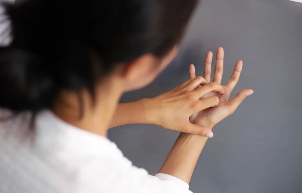 Femeie cu dishidroză manifestă disconfort la nivelul palmelor și mâinilor