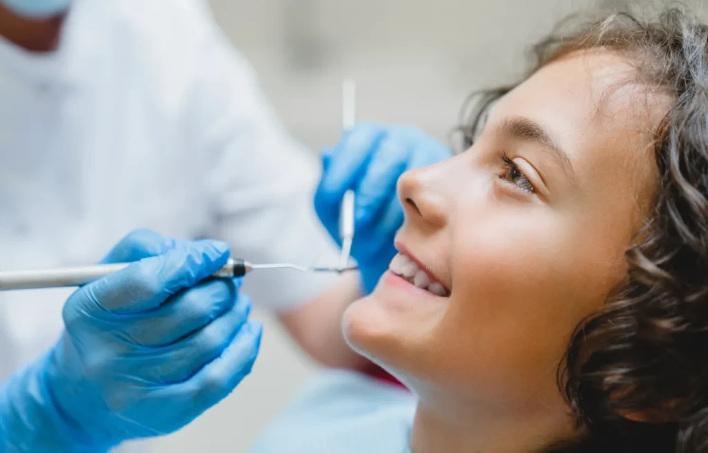 Copil la control stomatologic - examinare dentară profesională pentru dinți sănătoși